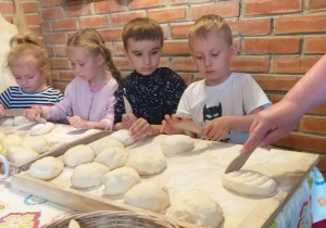 Dzieci przygotowują chleb do wypieku.